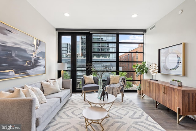 living room featuring recessed lighting, floor to ceiling windows, visible vents, and wood finished floors