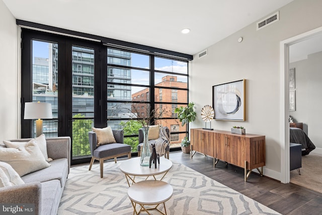 living area with a wall of windows, visible vents, and plenty of natural light