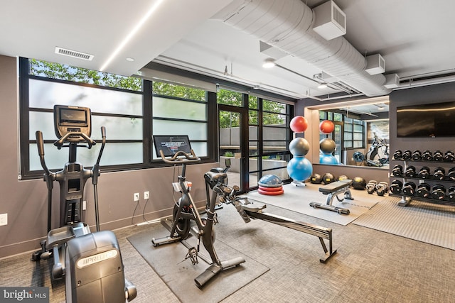 exercise room with visible vents and baseboards