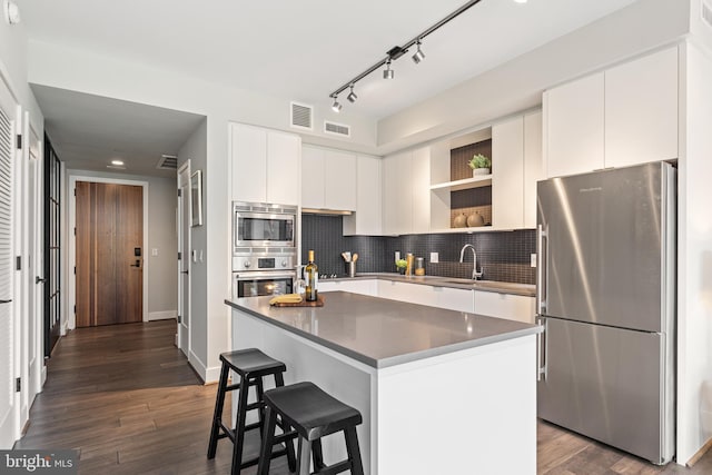 kitchen with open shelves, appliances with stainless steel finishes, dark wood-type flooring, and visible vents