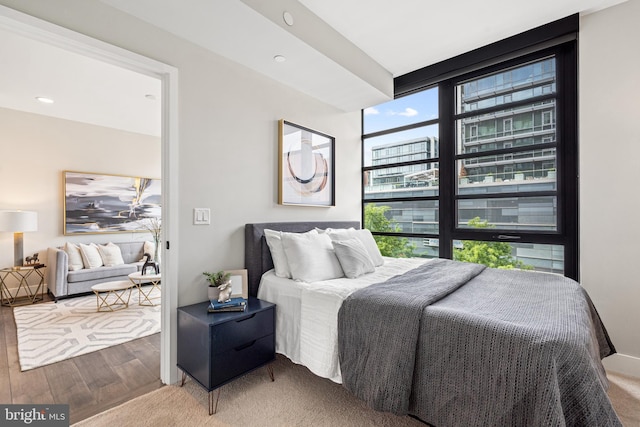 bedroom featuring multiple windows and wood finished floors