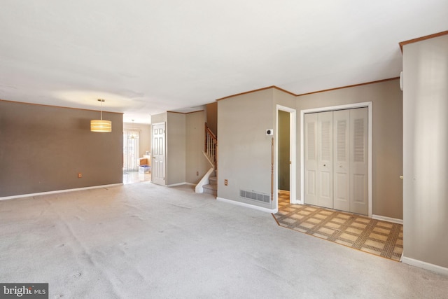 unfurnished living room featuring carpet, baseboards, visible vents, ornamental molding, and stairs