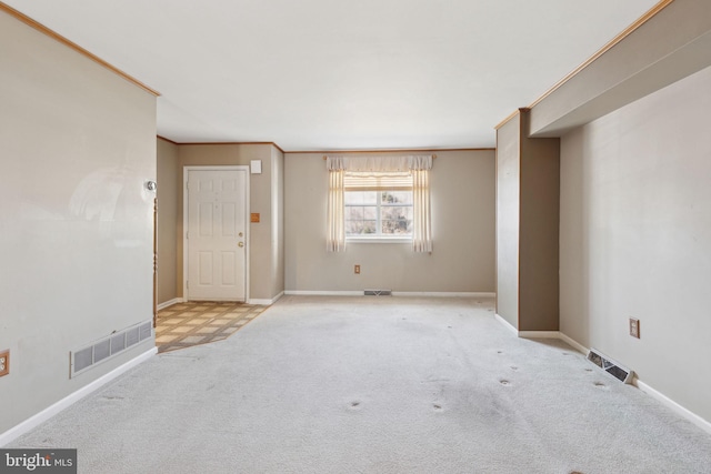 unfurnished room featuring visible vents, carpet floors, and crown molding