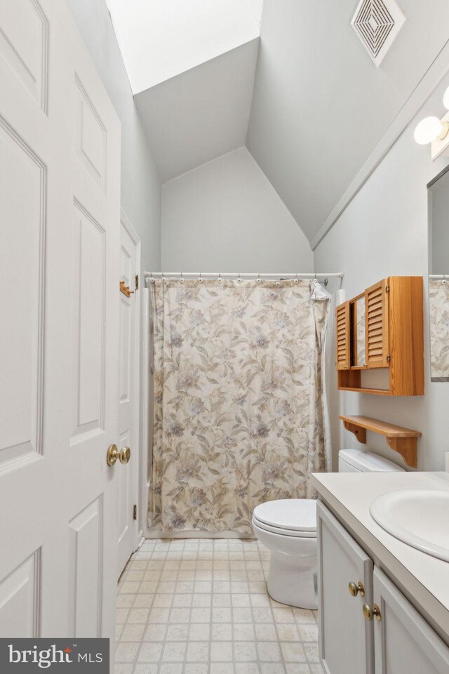 bathroom featuring vanity, visible vents, lofted ceiling, tile patterned floors, and toilet