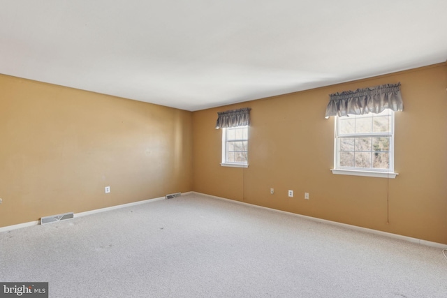 carpeted spare room with baseboards and visible vents