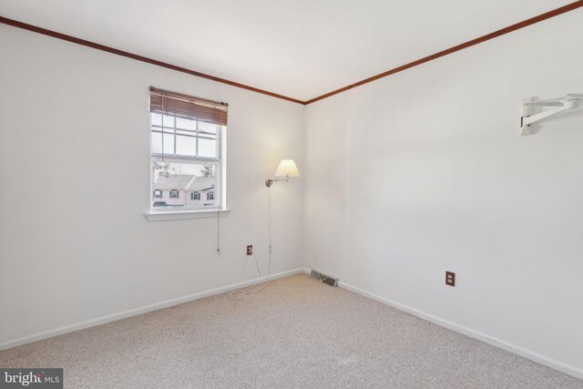 unfurnished room featuring carpet flooring, baseboards, visible vents, and ornamental molding