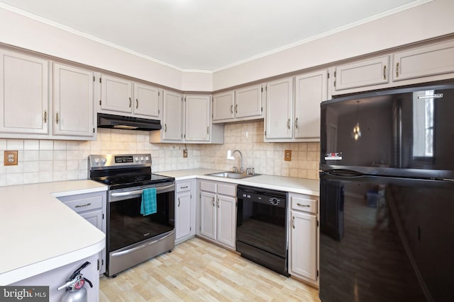 kitchen with backsplash, crown molding, under cabinet range hood, black appliances, and a sink