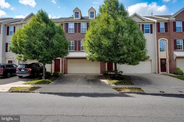 townhome / multi-family property featuring driveway, an attached garage, and brick siding