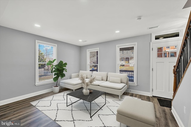 living area with recessed lighting, visible vents, stairway, wood finished floors, and baseboards