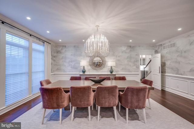 dining room featuring a wainscoted wall, dark wood-type flooring, visible vents, an inviting chandelier, and crown molding