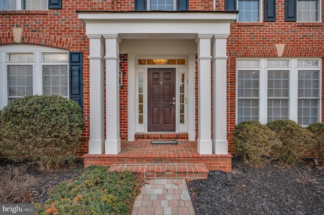 doorway to property with brick siding