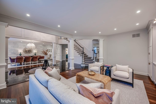 living room featuring dark wood-style flooring, visible vents, ornamental molding, stairway, and decorative columns