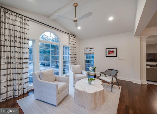 sitting room featuring vaulted ceiling with beams, ornate columns, a ceiling fan, wood finished floors, and baseboards