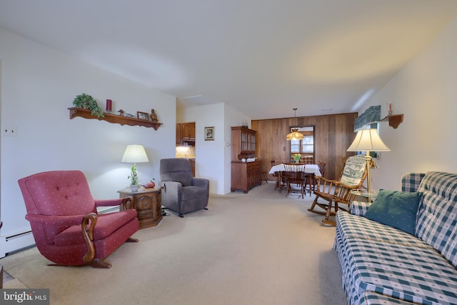 living room with wood walls, a baseboard radiator, and carpet flooring