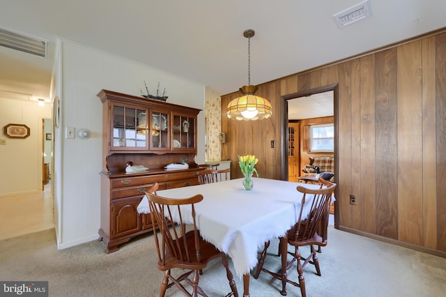 dining room featuring baseboards, visible vents, and light colored carpet