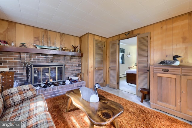 living area featuring baseboard heating, a fireplace, and wooden walls