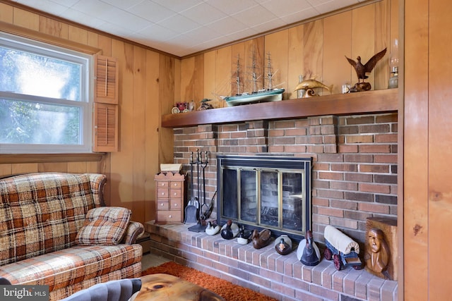 living room featuring wood walls, a fireplace, and crown molding