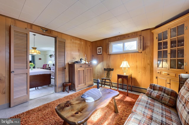 living area featuring a baseboard radiator and wooden walls