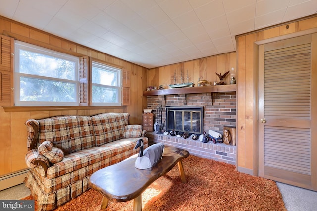 living room featuring wood walls, a fireplace, and baseboard heating