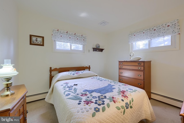 bedroom featuring visible vents, baseboard heating, and multiple windows