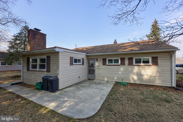 rear view of house with a chimney and a patio area