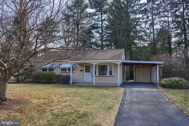 ranch-style home featuring a carport, roof with shingles, a front lawn, and aphalt driveway