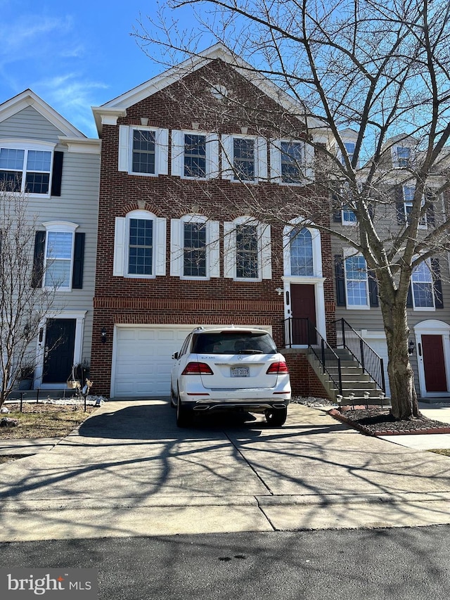 view of property with driveway, brick siding, and an attached garage