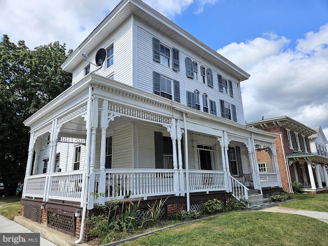 view of front of home featuring covered porch and a front yard