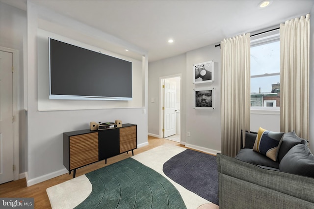 living room featuring baseboards, wood finished floors, and recessed lighting