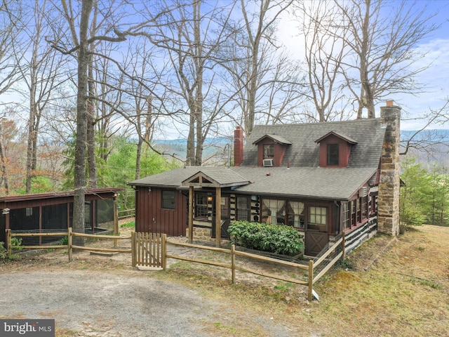 rustic home featuring a chimney, a shingled roof, and board and batten siding
