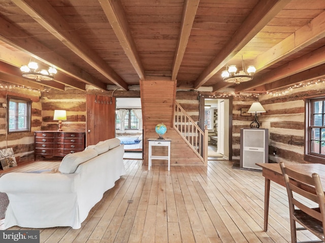 living room with hardwood / wood-style floors, a healthy amount of sunlight, an inviting chandelier, and stairway