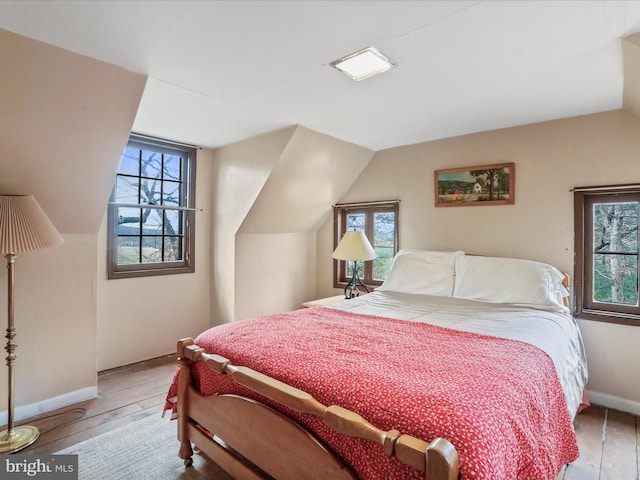bedroom featuring hardwood / wood-style flooring and multiple windows