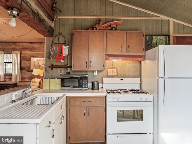 kitchen with white appliances, rustic walls, under cabinet range hood, a sink, and vaulted ceiling