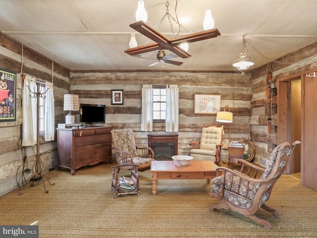 living room featuring a ceiling fan, wood ceiling, and a glass covered fireplace