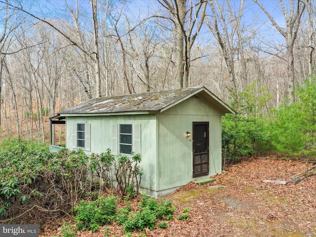 view of outbuilding with an outdoor structure and a view of trees