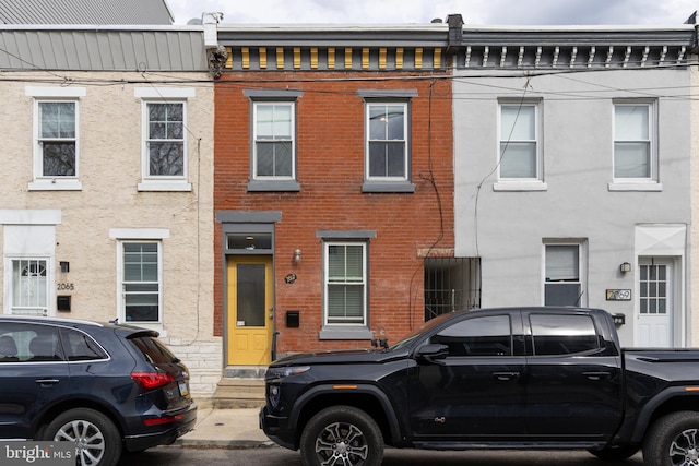 view of property with entry steps and brick siding