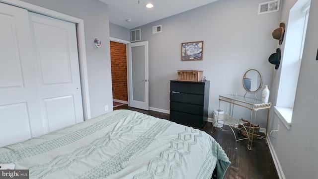 bedroom with wood finished floors, visible vents, and baseboards