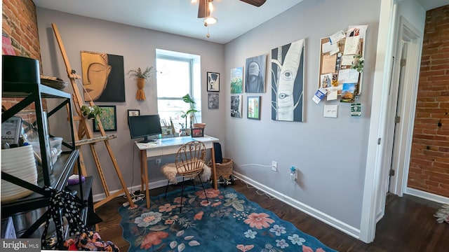 office area with ceiling fan, brick wall, wood finished floors, and baseboards