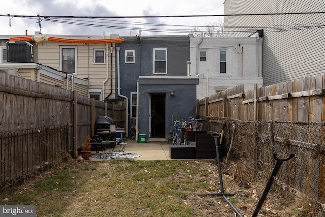 back of property with a patio, a fenced backyard, cooling unit, a yard, and stucco siding