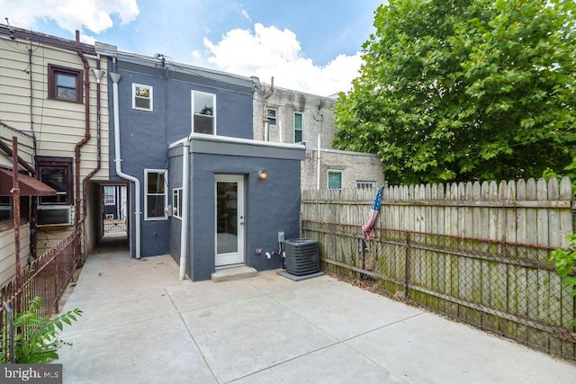 back of property featuring central AC, a patio, fence, and stucco siding