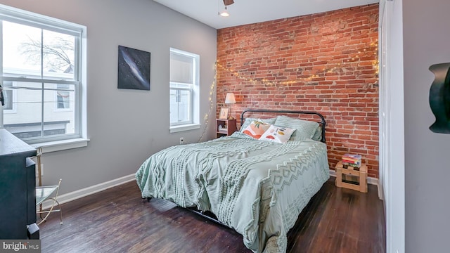 bedroom featuring multiple windows, wood finished floors, and baseboards