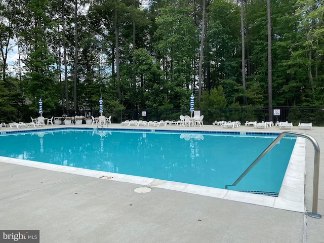 community pool featuring fence and a patio