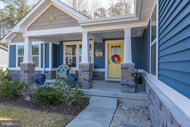 doorway to property featuring stone siding and a porch