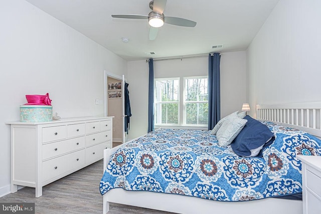 bedroom with visible vents, ceiling fan, and wood finished floors