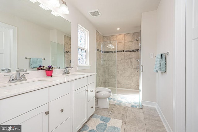 bathroom featuring double vanity, a stall shower, visible vents, and a sink