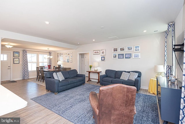 living area with recessed lighting, visible vents, baseboards, and wood finished floors