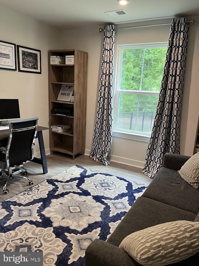 home office featuring baseboards, visible vents, and wood finished floors