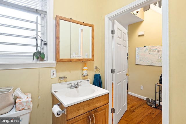 bathroom with vanity, baseboards, and wood finished floors