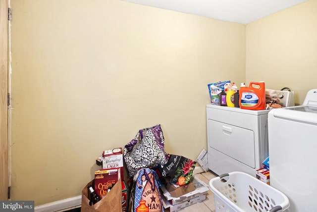 clothes washing area featuring laundry area, separate washer and dryer, and baseboards