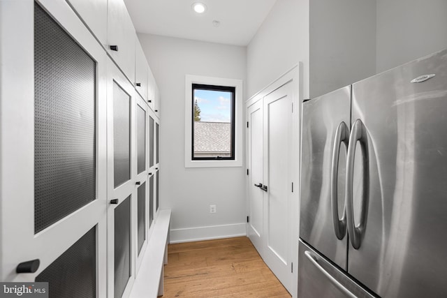 kitchen featuring recessed lighting, white cabinetry, baseboards, light wood-style floors, and freestanding refrigerator